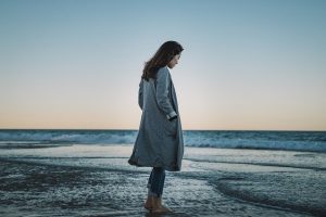 Kobieta spacerująca po plaży w chłodną porę roku – Dziwnów noclegi